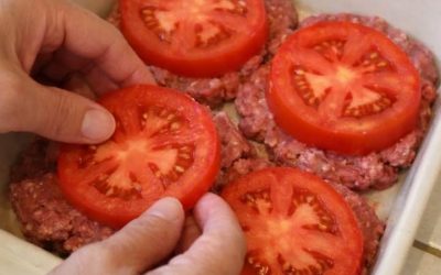 Keramikas cepamtraukā kārtojiet biezas neapstrādātu tomātu šķēles virs neapstrādātas maltās liellopa gaļas kotletēm, pievienojot divas sastāvdaļas, lai pagatavotu vienkāršas vakariņas, kas ir mana iecienītākā.